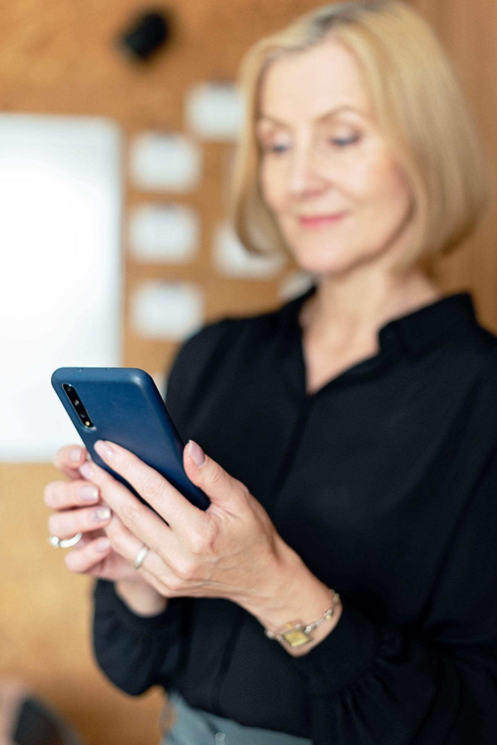 Woman smiling at her phone after booking a discovery call